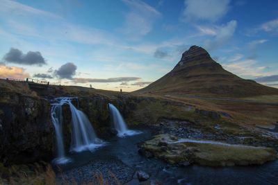 Scenic view of waterfall against sky