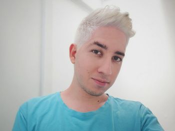 Close-up portrait of young man with dyed hair at home