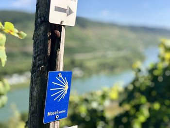 Close-up of sign on wooden post