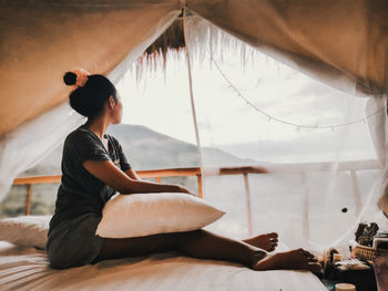 Side view of woman looking away at home