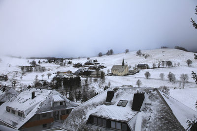 High angle view of snow covered houses against sky