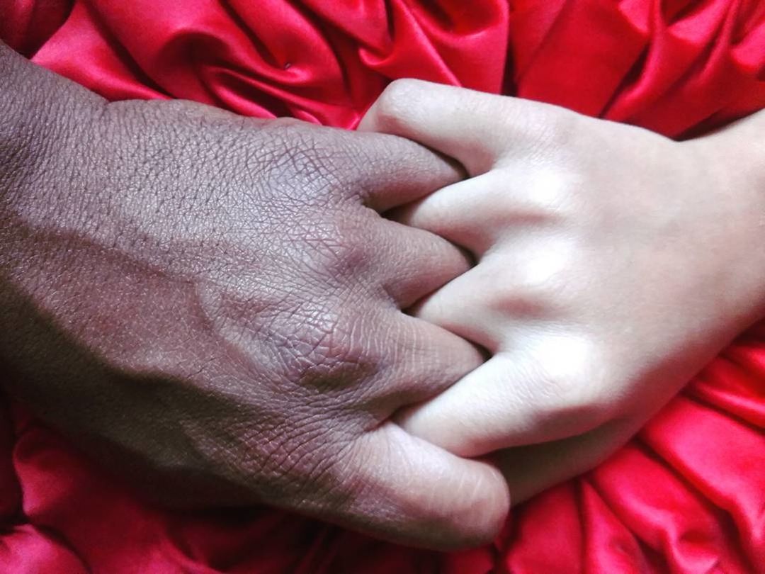 CLOSE-UP OF HANDS ON RED BABY