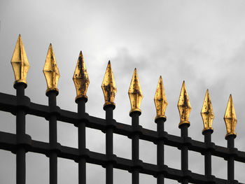 Low angle view of fence against sky