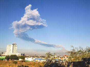 Panoramic view of city buildings against blue sky