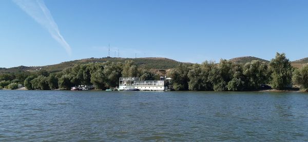 Scenic view of lake by trees against clear sky