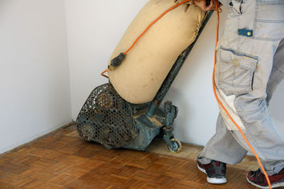 Man sanding hardwood floor with grinding machine
