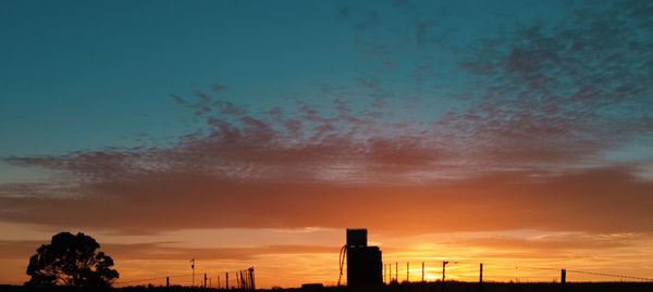 Silhouette buildings against sky during sunset