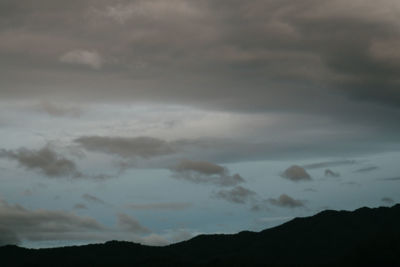 Low angle view of storm clouds at sunset