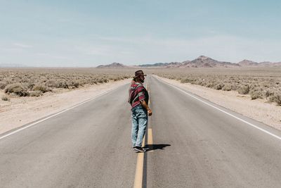 Rear view of man on road against sky