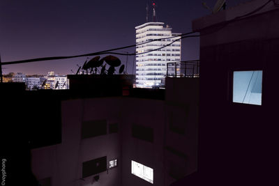 Low angle view of skyscrapers against sky at night