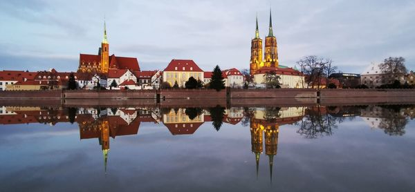 Reflection of buildings in lake against sky