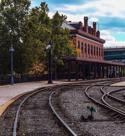 Railroad tracks against cloudy sky