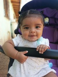 Portrait of baby girl sitting in stroller