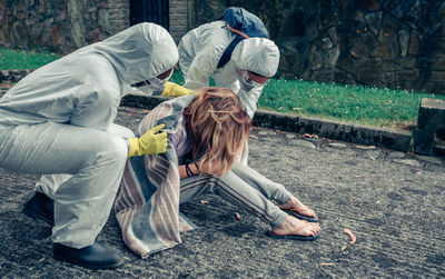 Doctors wrapping patient with blanket at hospital