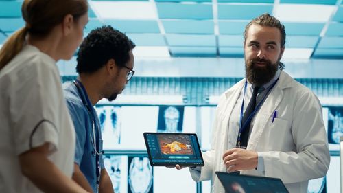 Side view of doctor using digital tablet