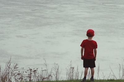 Boy standing on shore against sea