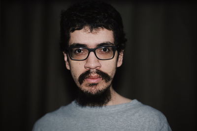 Portrait of young man against black background