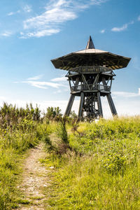 Traditional windmill on field against sky