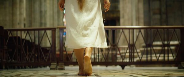 Low section of woman standing in city