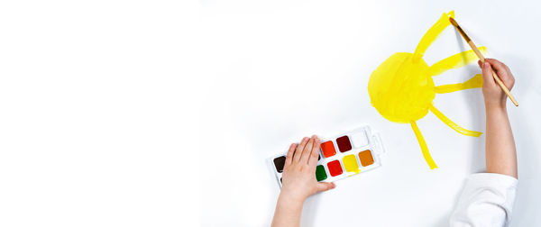 Cropped hand of woman holding gift against white background