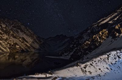 Scenic view of snowcapped mountains against sky at night