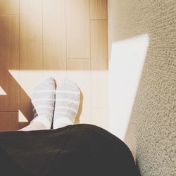 Low section of woman sitting on sofa at home