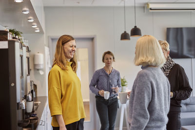Women talking in office kitchen