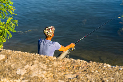 Rear view of man fishing in sea