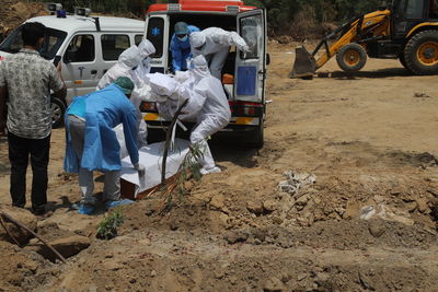 Rear view of people working on road