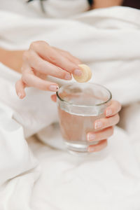 Midsection of woman holding drink on table