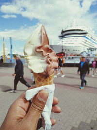 Midsection of man holding ice cream in city