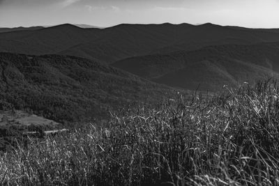 Scenic view of land and mountains against sky