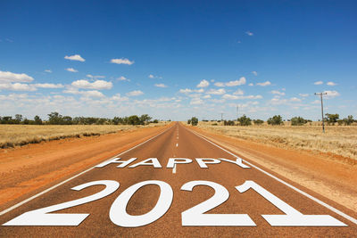 Road passing through landscape against blue sky