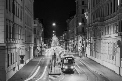 Cars on road amidst buildings in city at night