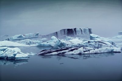 Icebergs floating in sea against sky