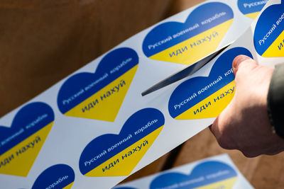 Preparing stickers heart shape with colors of ukraine during a peaceful demonstration against war