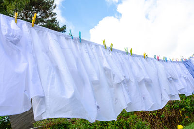 Low angle view of clothes drying on clothesline against sky