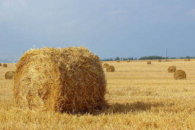 Hay bales on field against sky