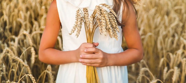 Midsection of woman standing against plants