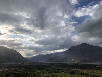 Scenic view of mountains against cloudy sky