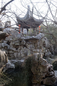 Stone wall by building and trees