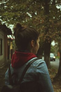 Rear view of woman standing on footpath 