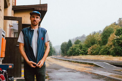 Portrait of young man standing against train