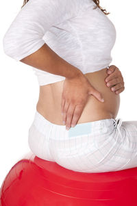 Midsection of woman with umbrella against white background