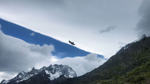 Low angle view of snowcapped mountains against sky