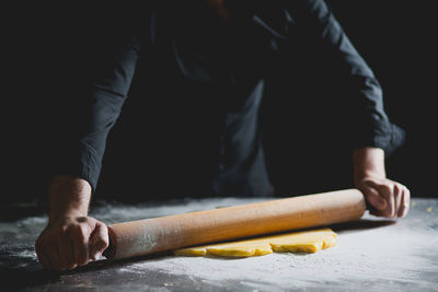 Cropped view of chef rolling pastry dough
