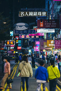 People walking on city street at night