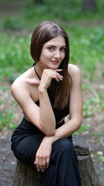 Portrait of young woman sitting outdoors