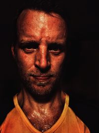 Close-up portrait of mid adult man against black background