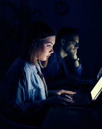 Woman with man using laptop